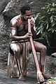 Aboriginal Australian playing the Didgeridoo, a musical instrument (Behaviors: musicality, body adornment)