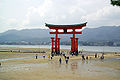 Tourists visit torii at low tide