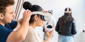 Jugendliche beim Aufsetzen von VR-Brillen