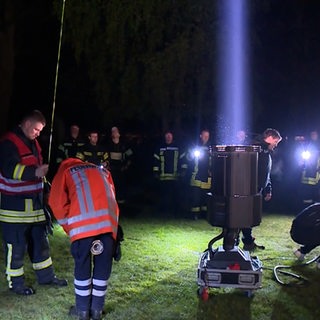 Ein Scheinwerfer leuchtet in den Himmel. 