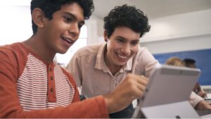 Zwei Schüler schauen gemeinsam auf einen Laptop