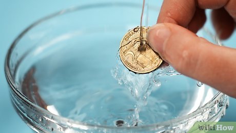 Step 1 Hold the coin under cold water.
