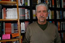 Tom Hayden in front of a bookshelf