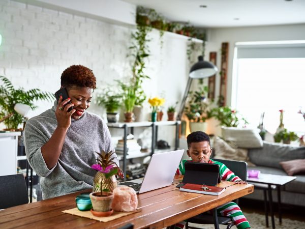 Mother and son at home, each on a mobile device