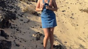 Girl pee in jeans skirt on the public beach