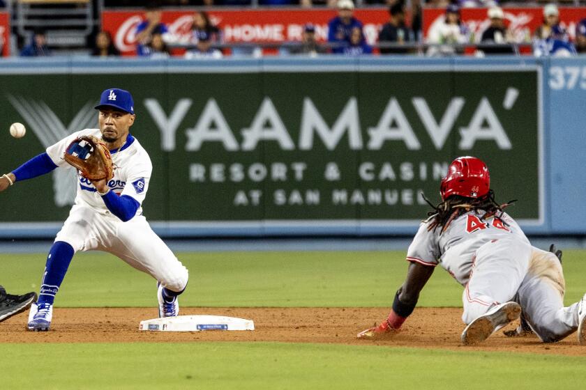 LOS ANGELES, CA - MAY16, 2024: Los Angeles Dodgers shortstop Mookie Betts (50) takes the throw from Los Angeles Dodgers catcher Austin Barnes (15) to tag out Cincinnati Reds shortstop Elly De La Cruz (44) attempting to steal in the seventh inning at Dodger Stadium on May 16, 2024 in Los Angeles, California.(Gina Ferazzi / Los Angeles Times)