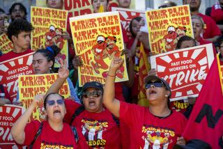 LOS ANGELES, CA-JULY 13, 2023: Angelica Hernandez, left, an employee for the past 20 years at a McDonald's restaurant in Monterey Park, and Anneisha Williams, right, an employee for the past 10 years at a Jack in the Box restaurant in Los Angeles, rally with other fast food workers from across Los Angeles during a rally outside of the Los Angeles Chamber of Commerce in Los Angeles. The rally was held to raise awareness of their push for better working conditions. (Mel Melcon / Los Angeles Times)