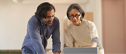 A man and woman looking at a laptop