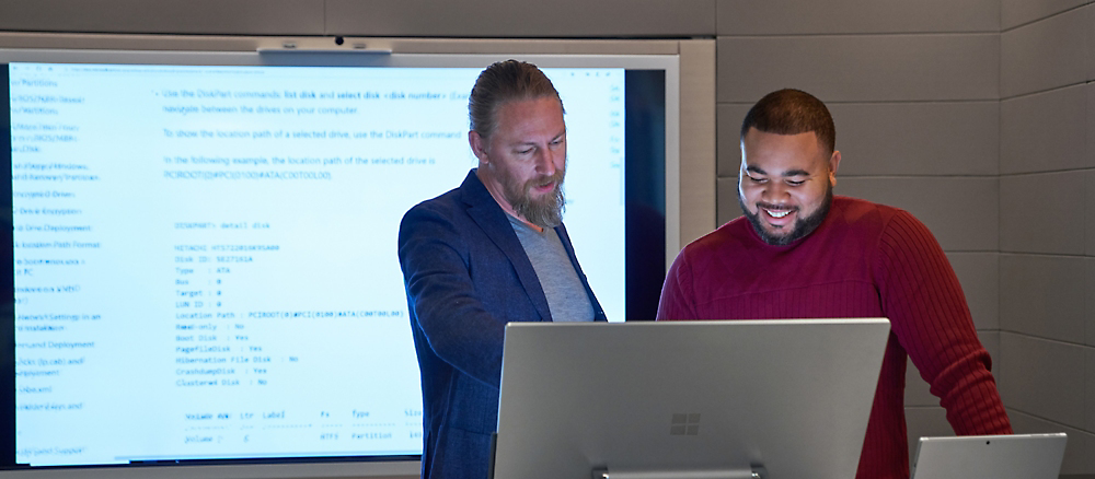 A group of men standing in front of a computer