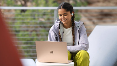 Eine Person arbeitet im Freien mit einem Surface Laptop 5