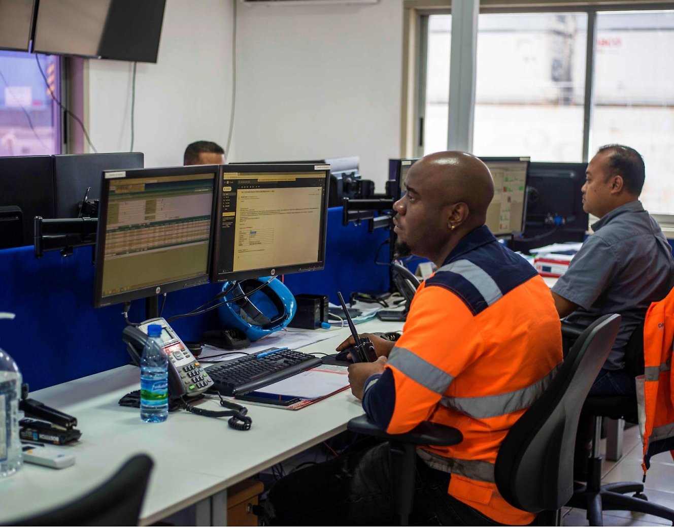 Two persons wearing safety jackets working on the desktop