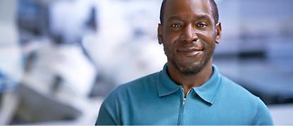 A black man smiling in a blue shirt