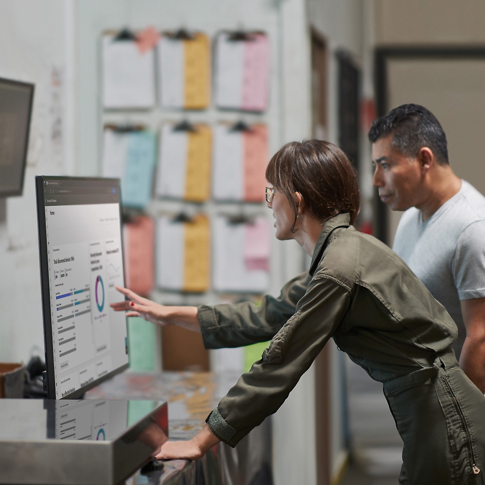 Two professionals analyzing data on a computer screen in an office environment.