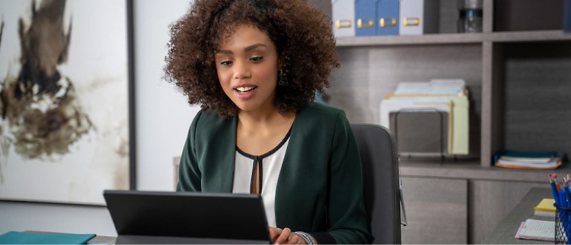 A woman sitting in office and working on her laptop