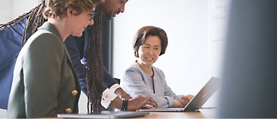 A group of business people working together on a laptop.