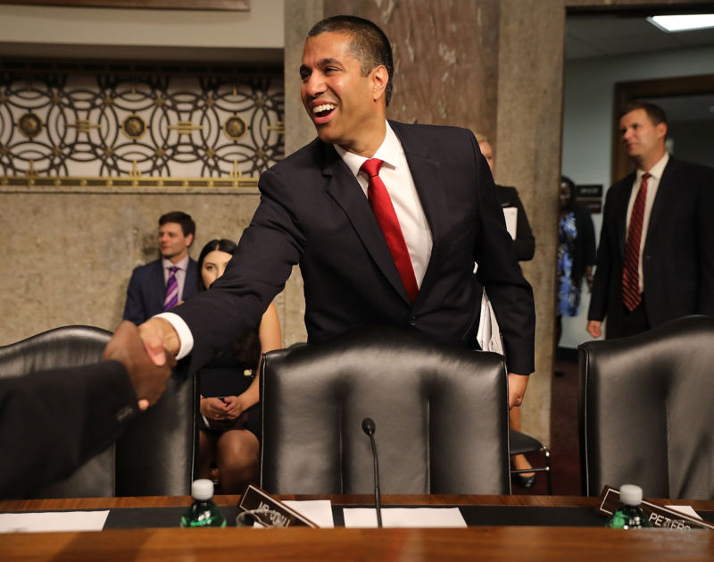 FCC Chairman Ajit Pai smiling and shaking someone's hand at his Senate confirmation hearing.