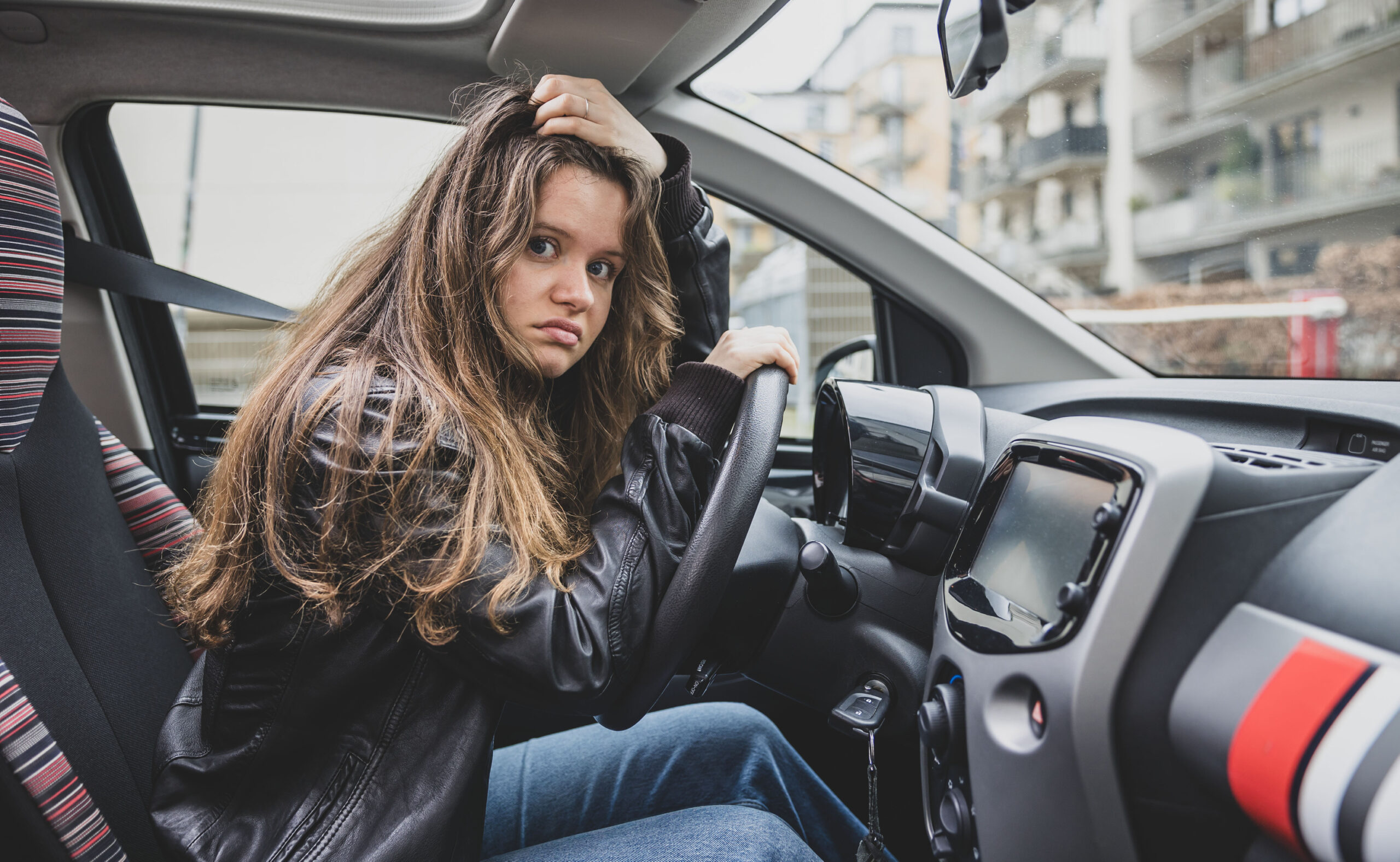 Zoe Clausen hinterm Lenkrad (im stehenden Auto), sie rauft sich die Haare