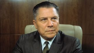 Teamster leader Jimmy Hoffa sitting in a chair.