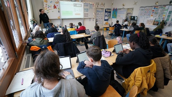 Mathe-Lehrer Tobias Weidenhöffer-Griese (hinten l) leitet den digitalen Mathe-Unterricht in der Klasse 5f in der Lessing-Stadtteilschule in Harburg-Wilstorf. 