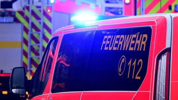 Fahrzeuge der Feuerwehr sind mit eingeschaltetem Blaulicht im Einsatz.