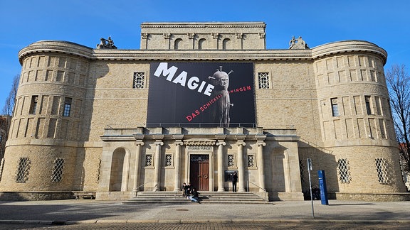 Außenansicht Gebäude Landesmuseum mit einem Banner auf dem Magie steht.