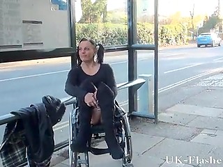 Ondeugend Brits meisje met staartjes zit in een rolstoel en laat haar geschoren poesje en tieten zien
