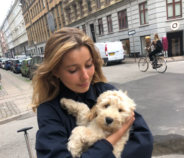 Een foto van een vrouw met een hond in haar armen.