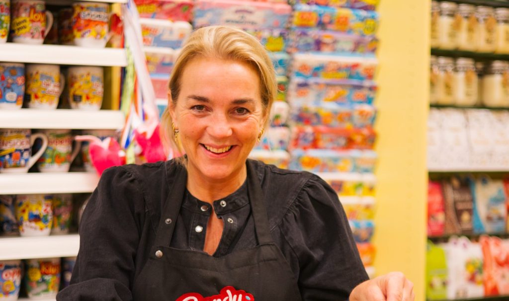 Onderneemster Candy Shop schept een zak snoep in haar winkel