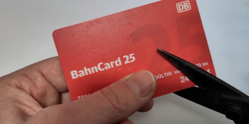 Eine Bahncard 25 wird mit einer Schere zerschnitten.