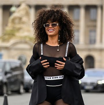 een vrouw op straat in parijs in een doorzichtige zwarte top