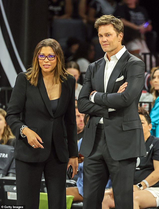 The former athlete looked dapper for the occasion, sporting a crisp black suit and white button up as he stood clapping for the team