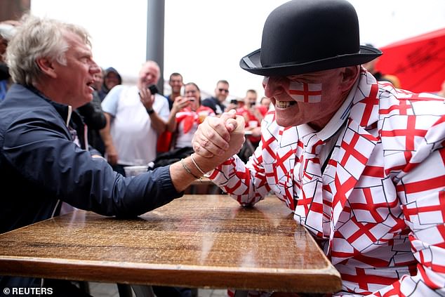 An England supporter in a St George's cross suit was seen arm wrestling in Gelsenkirchen