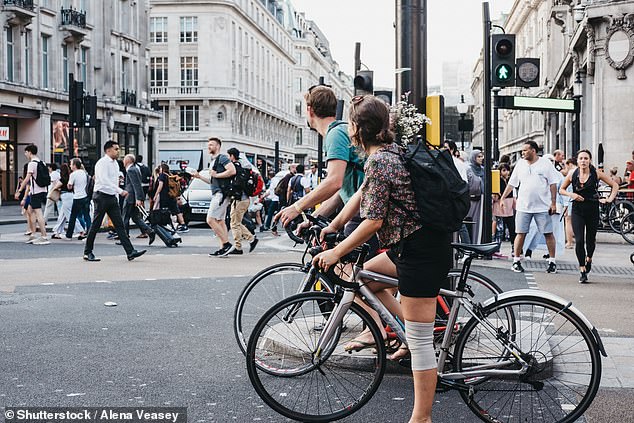 It is not currently a legal requirement to wear a helmet while cycling in the UK. Pictured here cyclists waiting for the traffic to change in London