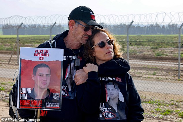 Relatives of Israeli hostages held by the Palestinian Hamas movement carry a picture of Omer Neutra, 22, in Kibbutz Nirim along the fence on the Gaza border on January 11, 2024