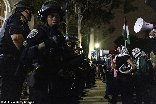 Police face off in lines against organized protesters who screamed at them through loudspeakers