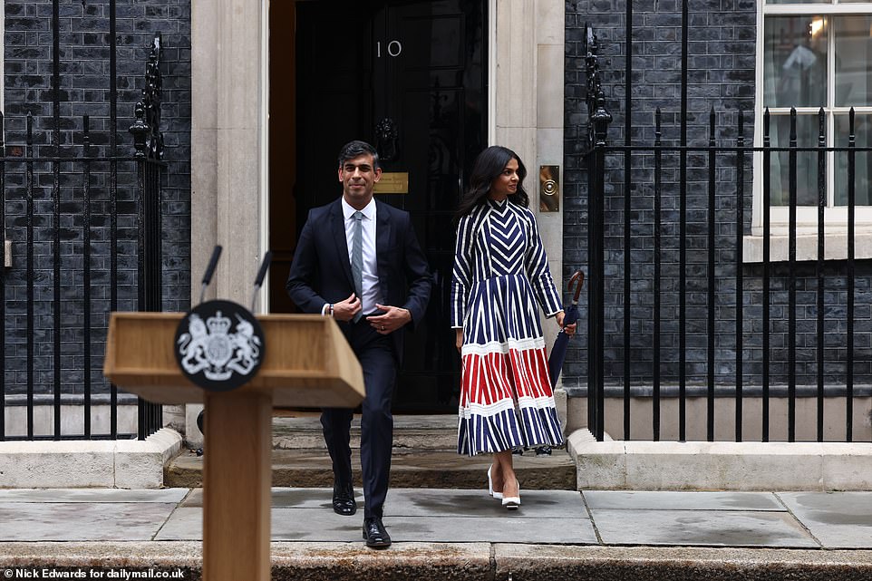 Akshata was carrying an umbrella as the couple emerged in Downing Street - as it was threatening to rain as it did when he announced the election
