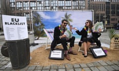 Oxfam activists in Brussels mimic wealthy people hiding their money to protest about the EU tax haven blacklist