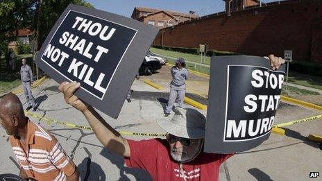 An anti-death penalty protester stands outside the the Texas Department of Criminal Justice Huntsville Unit (26 June 2013)