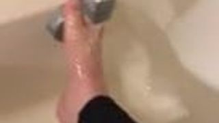 Alexis Black reibt ihre Füße in der Badewanne mit Leggings
