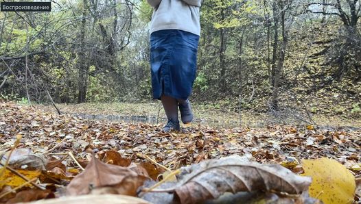 Kurvige MILF in einem langen Rock, pisst im Herbstpark