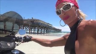 Sexy Leder-Biker in Oberschenkelstiefeln am Strand