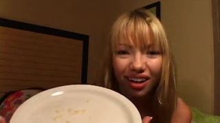 Schönes asiatisches Mädchen spuckt Schleim auf eine Platte und zeigt uns