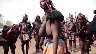 Afrikanska himba -kvinnor dansar och svänger sina hängande bröst runt