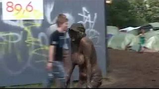 Oben-ohne-dänisches Mädchen bedeckt mit Schlamm beim Roskilde-Festival