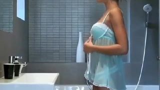Mädchen in einem Babydoll strippt vor der Dusche
