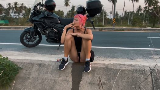 Dziewczyna z motocykla sika na poboczu drogi