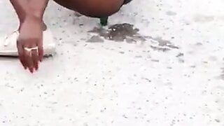 Ragazza giamaicana che scopa con una bottiglia di orso