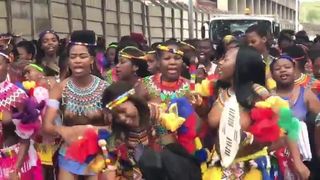 Grupa topless afrykańskich dziewcząt tańczy na ulicy