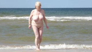 Ehefrau zieht sich am Strand aus