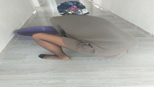 Turkisk kvinna i hijabs nylonstrumpor torkar golv